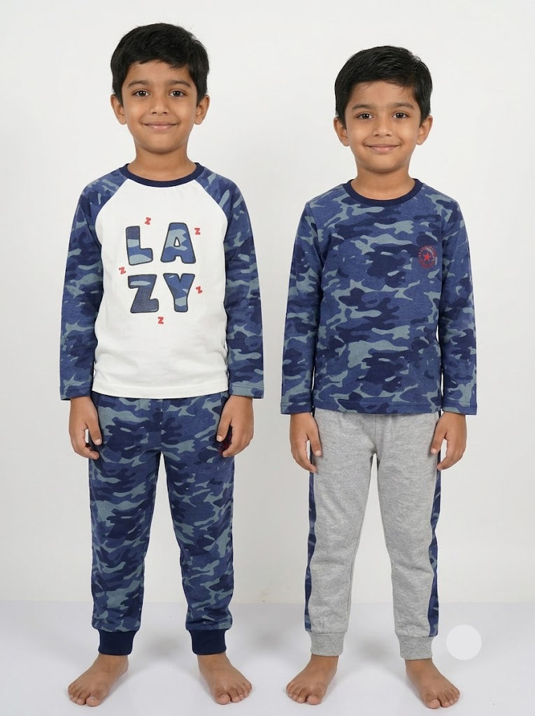 Two young boys modeling long-sleeve pajama sets against a plain white studio background. The boy on the left wears a blue and white camouflage pajama set with 'LAZY' printed on the front, and the boy on the right wears a matching blue camouflage pajama set with gray sweatpants.