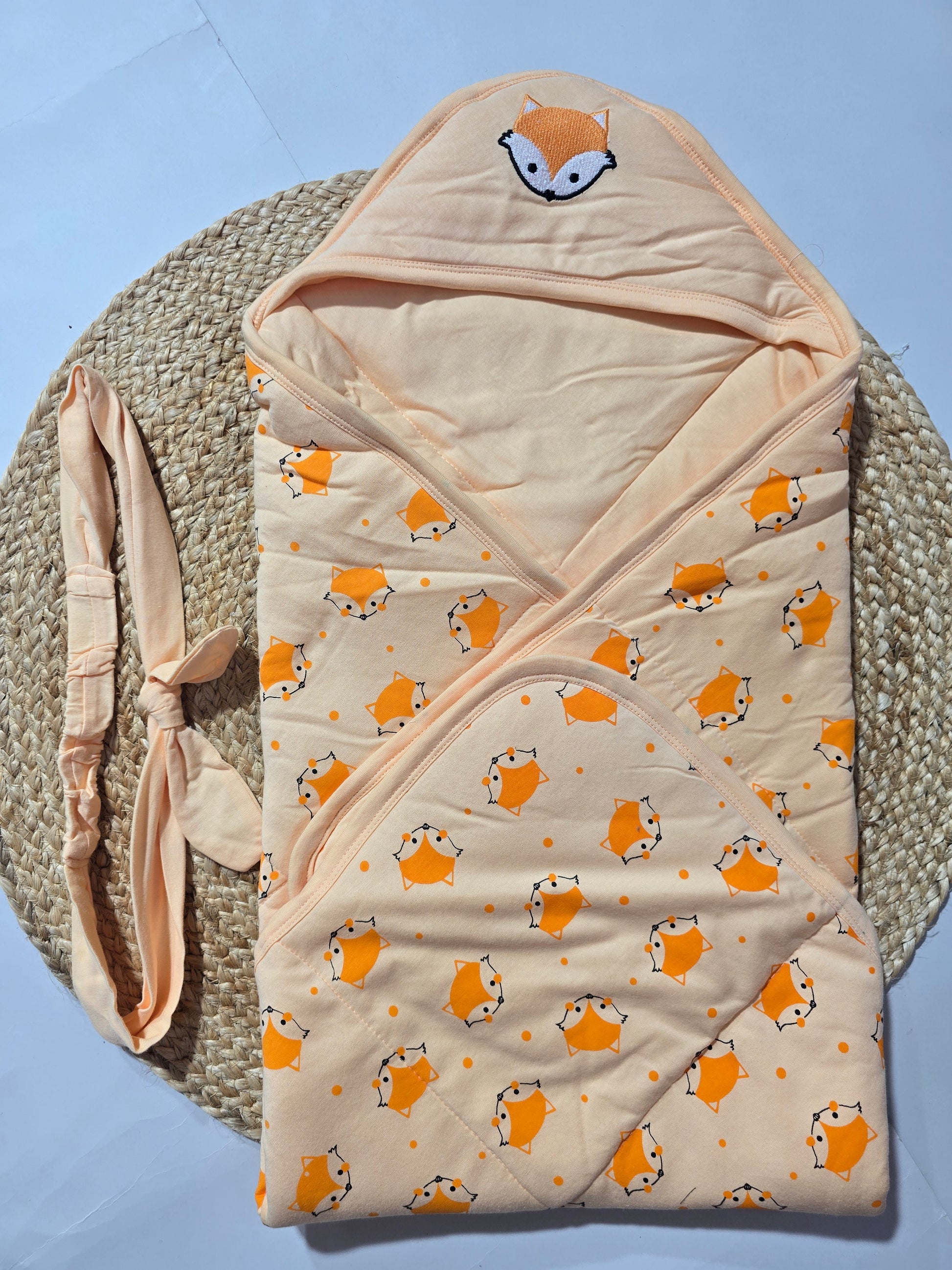 Baby wrap with fox pattern on a textured surface